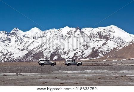 NGARI, TIBET AUTONOMUS REGION OF CHINA - APRIL 26, 2013: Off-road vehicles goes on the mountain way in Ngari prefecture Western Tibet