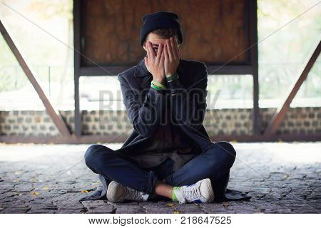 Teen covered his face, peeking through his fingers in the street