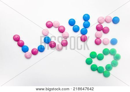 word Love lined with bright sweets on a white background.Concept love
