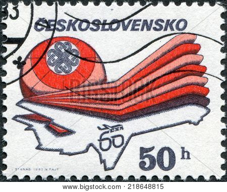 CZECHOSLOVAKIA - CIRCA 1983: A stamp printed in the Czechoslovakia is dedicated to the 60th anniversary of the Czechoslovak Airlines and the World Communications Year shows a passenger aircraft Ilyushin Il-62 and the emblem circa 1983