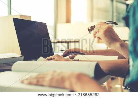University students using laptop for research homework in college