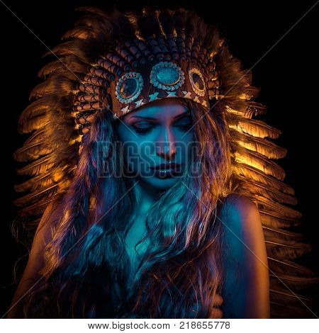 Colorful, beautiful girl with plume of american indian feathers