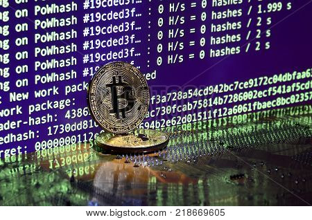 The digital process of cryptocurrency mining by using the GPUs. Bitcoins and video card on a working display and mining screen