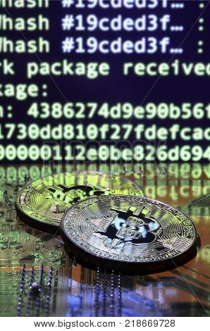 The digital process of cryptocurrency mining by using the GPUs. Bitcoins and video card on a working display and mining screen