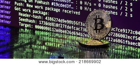 The digital process of cryptocurrency mining by using the GPUs. Bitcoins and video card on a working display and mining screen
