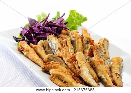 Fried fish Greek Sardices with lettuce and cabbage