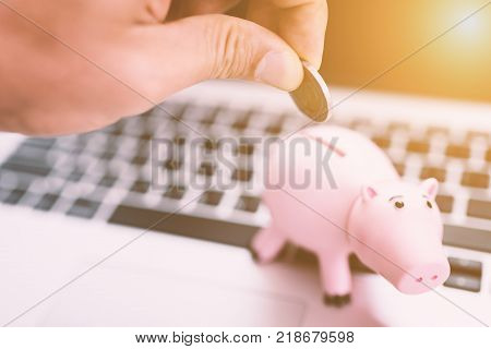 Young asian man putting coin into the piggy bank,support and helping concept.