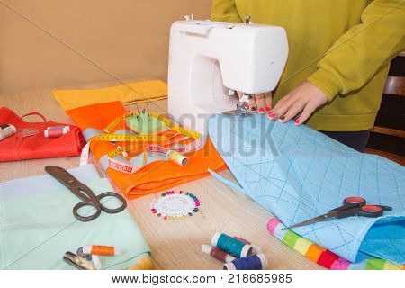 Sewing machine. Female fashion designer working. Dressmaker work on the sewing machine. Tailor making a garment in workplace. Hobby sewing fabric as a small business concept