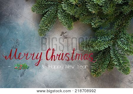 Christmas background with efresh vergreen tree banches close up with Merry Christmas greeting
