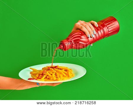 Young woman with plate of french fries potato with ketchup on green background