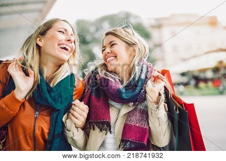 Happy friends shopping. Two beautiful young women enjoying shopping in the city.