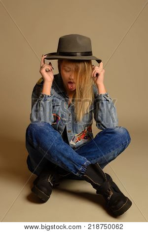 Teenage Girl Sitting On The Floor Showing The Tongue