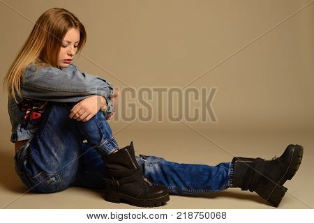 Teenage Girl Sitting On The Floor Showing The Tongue