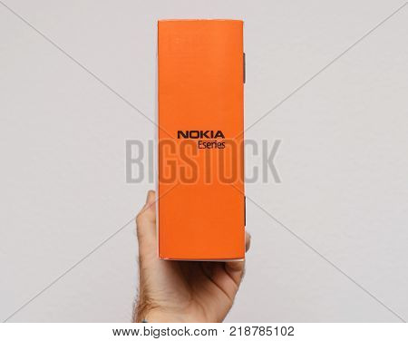 PARIS FRANCE - DEC 18 2017: Man holding against white background vintage and luxury NOKIA box of a E71 eseries business smartphone - orange side