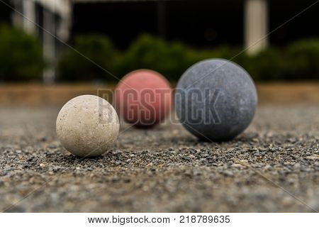 Bocce Balls on Gravel White in Focus with Red and Blue in Background
