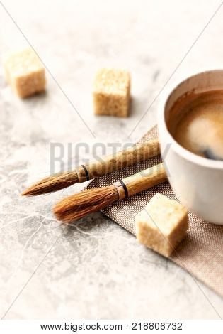 Two brushes Fude for Sumi-e painting and a Cup of coffee on rustic background