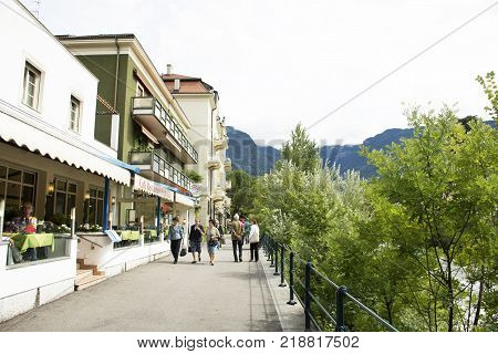 Italian People And Foreigner Travelers Walking Relax On Footpath At Riverside Of Passer River In Mer
