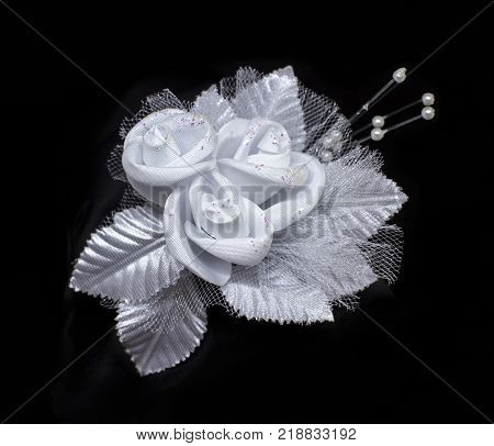 Wedding lace artificial flower with pearls isolated on black background