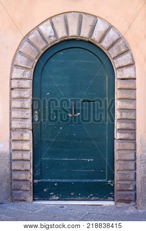 Ancient wooden door with knocker wrought iron handicraft