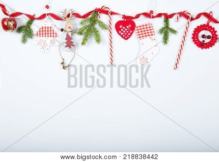 Christmas holiday composition. Festive creative red pattern, xmas handmade decor holiday with ribbon, candy canes, gift, christmas tree and decorations on white background. Flat lay, top view