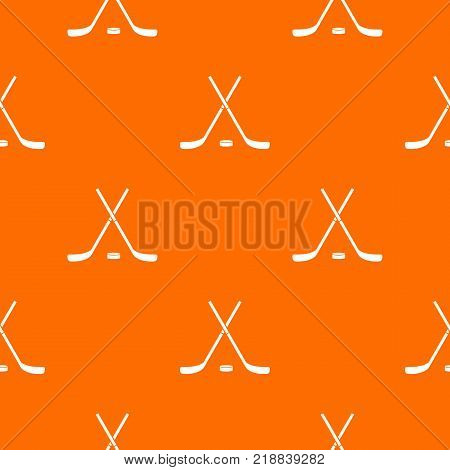 Crossed hockey sticks and puck pattern repeat seamless in orange color for any design. Vector geometric illustration