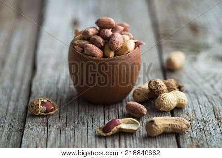 Peanut in shell texture and background. Peanuts texture. Shelled Peanuts. Healthy food. Close up view of shelled peanuts in wooden background. Abstract background and texture for designers.