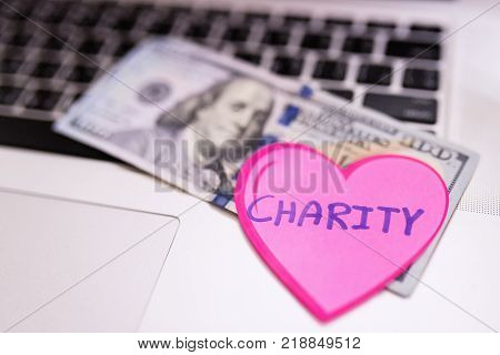 Paper red heart on laptop,charity,support and helping concept.