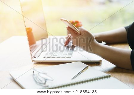 Woman using smartphone while working in the coffee shop.business,accounting concept.