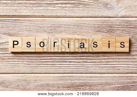 Psoriasis word written on wood block. Psoriasis text on table concept.
