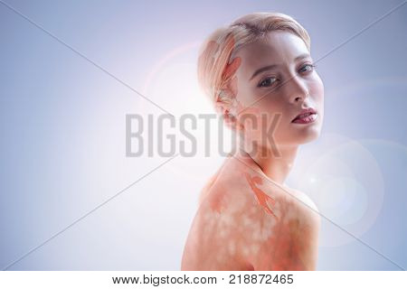 Autumn beauty. Beautiful nice young woman turning to you and imagining leaves while feeling autumn mood