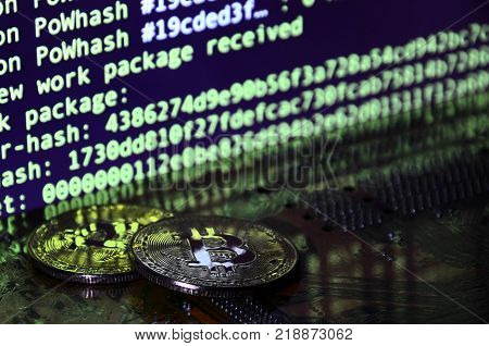 The digital process of cryptocurrency mining by using the GPUs. Bitcoins and video card on a working display and mining screen