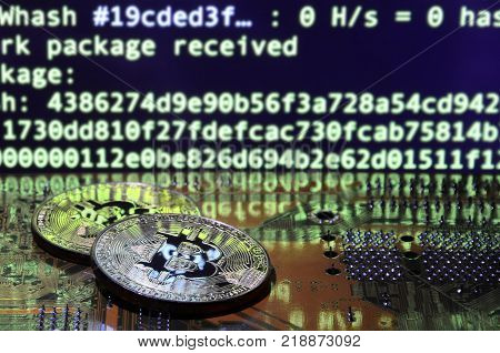 The digital process of cryptocurrency mining by using the GPUs. Bitcoins and video card on a working display and mining screen