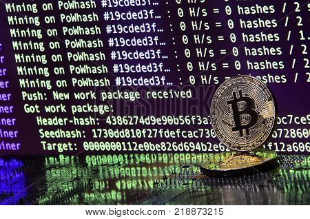 The digital process of cryptocurrency mining by using the GPUs. Bitcoins and video card on a working display and mining screen