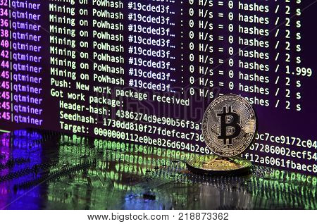 The digital process of cryptocurrency mining by using the GPUs. Bitcoins and video card on a working display and mining screen