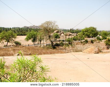 View of ancient ruins on Hemakuta hill in Hampi, Karnataka, India. Landscape with unique mountain formation with amazing stones, tropical nature and temple. UNESCO World Heritage Site