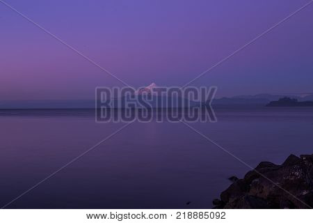 Volcano and lake in sunset in city
