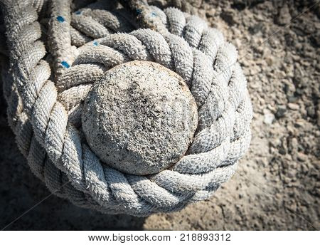 Details of a twisted Ship mooring strong rope on a bollard for securing fishing boats