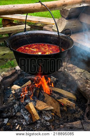 traditional Hungarian Goulash soup in cauldron. meal cooked outdoors on an open fire. delicious and healthy food popular in Central Europe