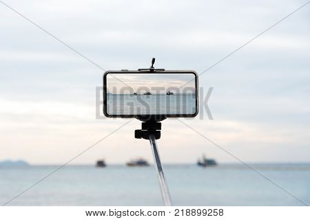 Mobile monopod with sea view screen phone Smartphone Monophonic visible in the arm.