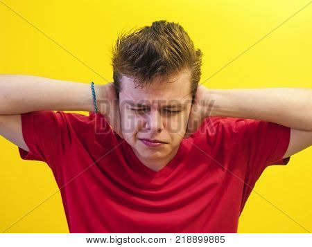 Close-up portrait of cauliflower ears and closes eyes, which will block sound, on a light background. He does not want to hear it. The concept of human emotions.