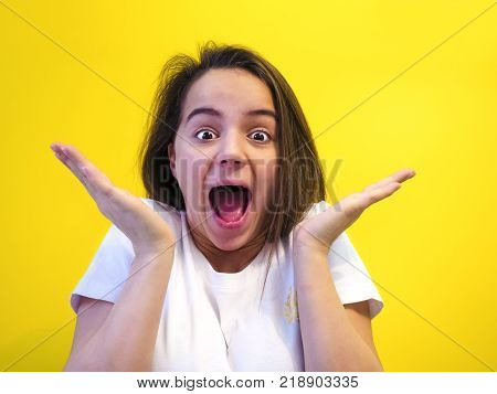 People, success, achievement and joy concept. Happy cheering female raises hands with excitement, screams YES, being lucky to reach goals, celebrates her victory, glad to recieve triumf