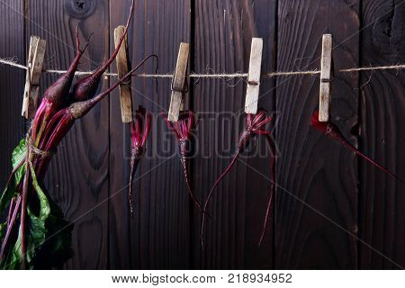 Fresh betroots hanging on string.Wooden background.Concept hanging herbs.closeup