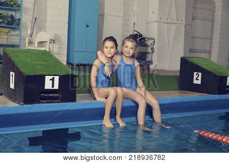 Two School Girls Sitting at a Pool