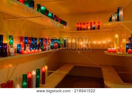 Colorful candle with flame in small room.