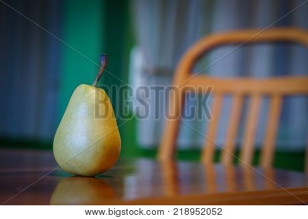 Fresh pear on wooden table with wooden chair in background