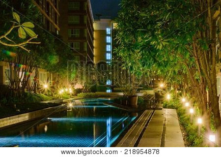 Courtyard of an apartment house with shallow blue pool.
