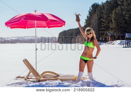 Novokuznetsk, Kemerovo region, Russia - 23 Feb, 2017 : White beaches of Siberia is an enterteiment activity where people playing beach games dressed in bikini in winter. Woman in bikini with pineapple