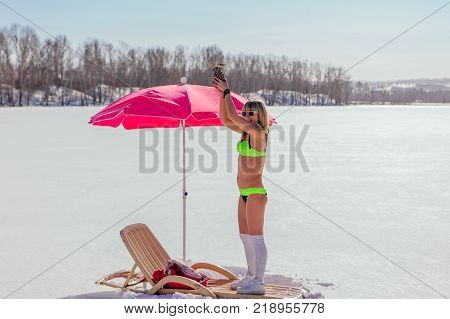 Novokuznetsk, Kemerovo region, Russia - 23 Feb, 2017 : White beaches of Siberia is an enterteiment activity where people playing beach games dressed in bikini in winter. Woman in bikini with pineapple