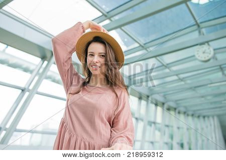 Young woman in international airport walking with her luggage.