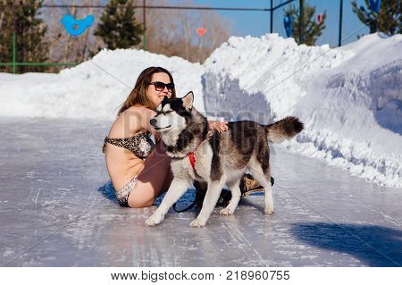 Novokuznetsk, Kemerovo region, Russia - 23 Feb, 2017 : White beaches of Siberia is an enterteiment activity where people playing beach games dressed in bikini in winter. Women in bikini with husky